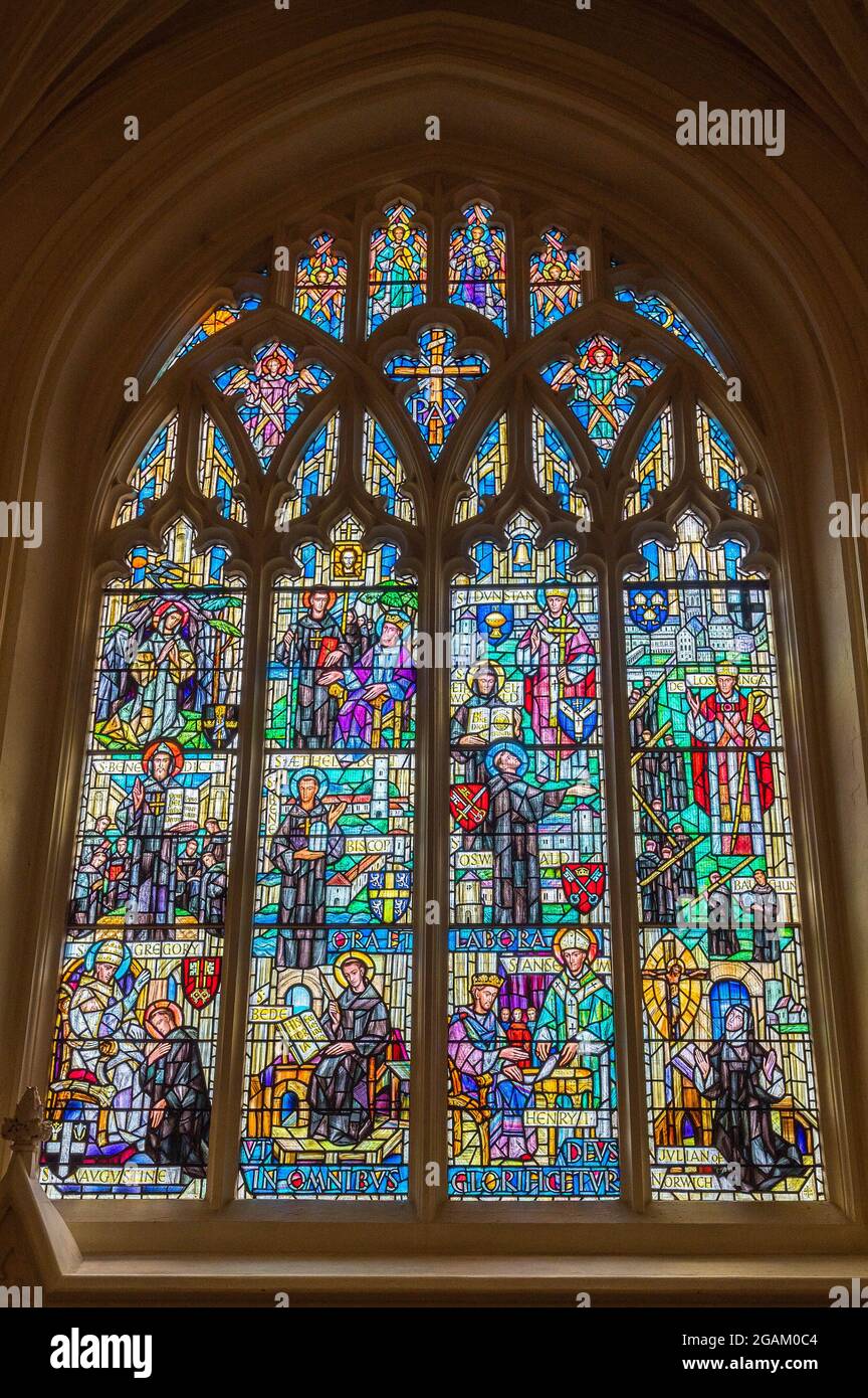 Bella finestra est vetrate a Norwich mediaevil cattedrale con il sole che splende attraverso Foto Stock