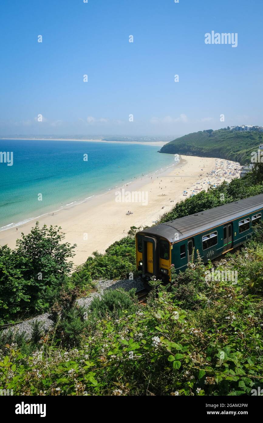 Un treno che passa le vedute della Baia di Carbis in Cornovaglia, Regno Unito. Foto Stock
