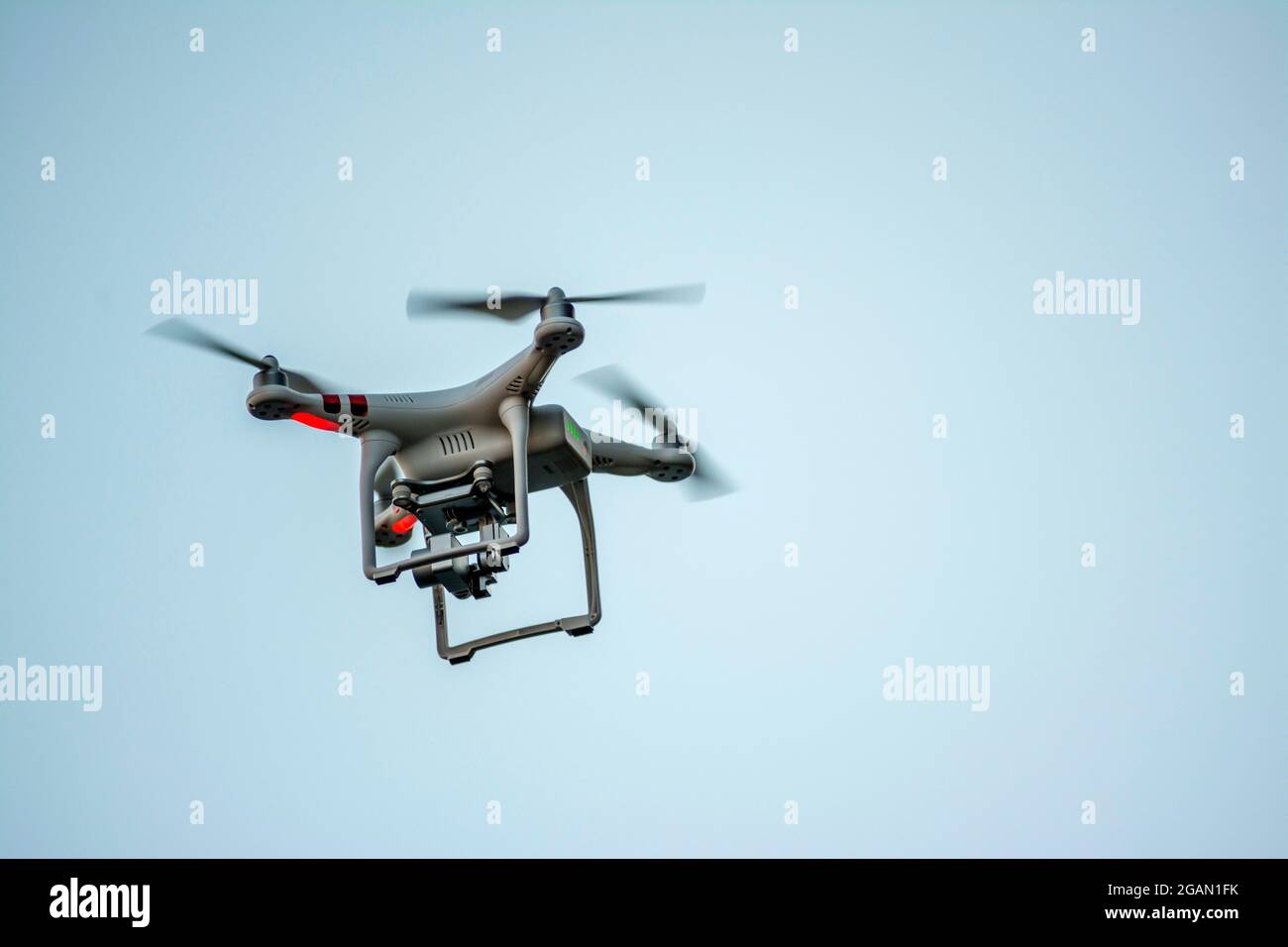 Un drone che vola in cielo aperto, catturando riprese aeree durante il giorno Foto Stock
