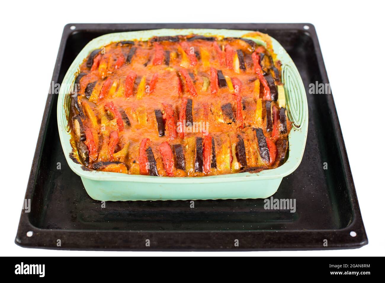 Vassoio di metallo con ratatouille piatto vegetariano appena cotto a base di zucchine, melanzane, pomodori, cipolle, patate, e una salsa speciale, isolata su un wh Foto Stock Vassoio di metallo con ratatouille piatto vegetariano appena cotto a base di zucchine, melanzane, pomodori, cipolle, patate, e una salsa speciale, isolata su un wh Foto Stock