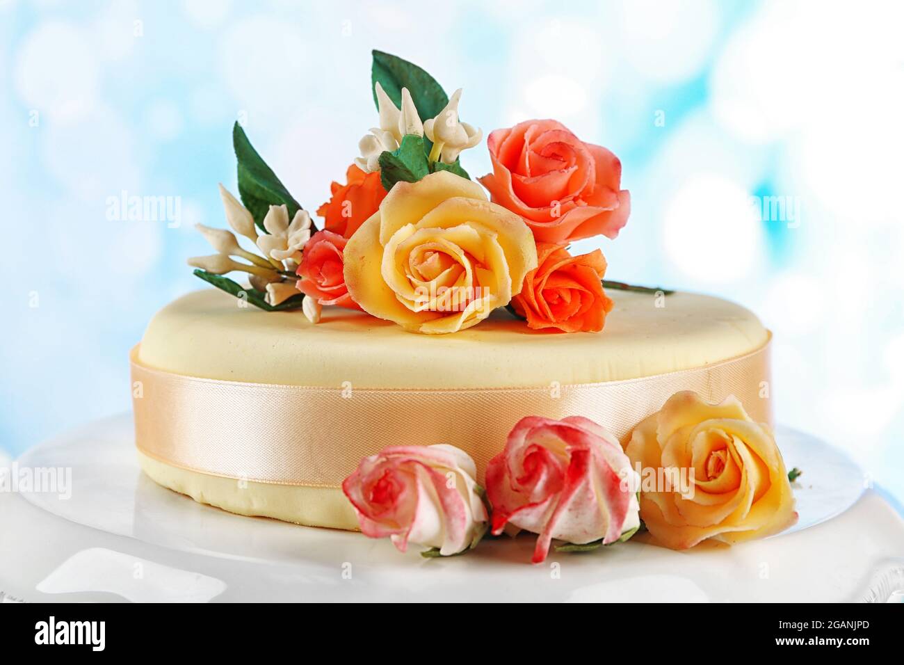 Torta con fiori di pasta di zucchero, su sfondo chiaro Foto stock - Alamy