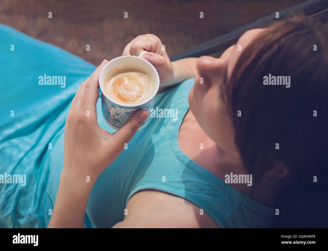 giovane caucasica donna felice bere caffè alla luce del sole, vista dall'alto. Foto Stock