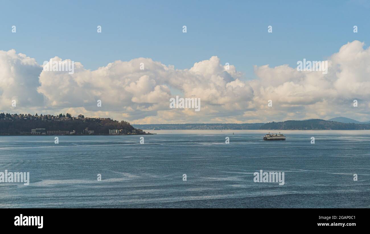 Washington Ferry naviga su Elliot Bay passando da West Seattle e Cloud Sky background Foto Stock