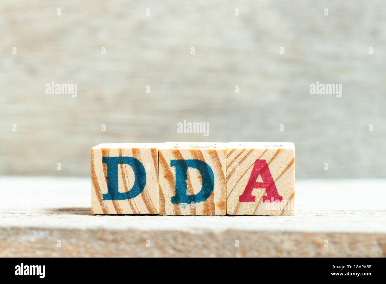 Blocco di lettere alfabetiche in parola DDA (abbreviazione di ammortamento, impoverimento e ammortamento o conto deposito domanda) su sfondo legno Foto Stock