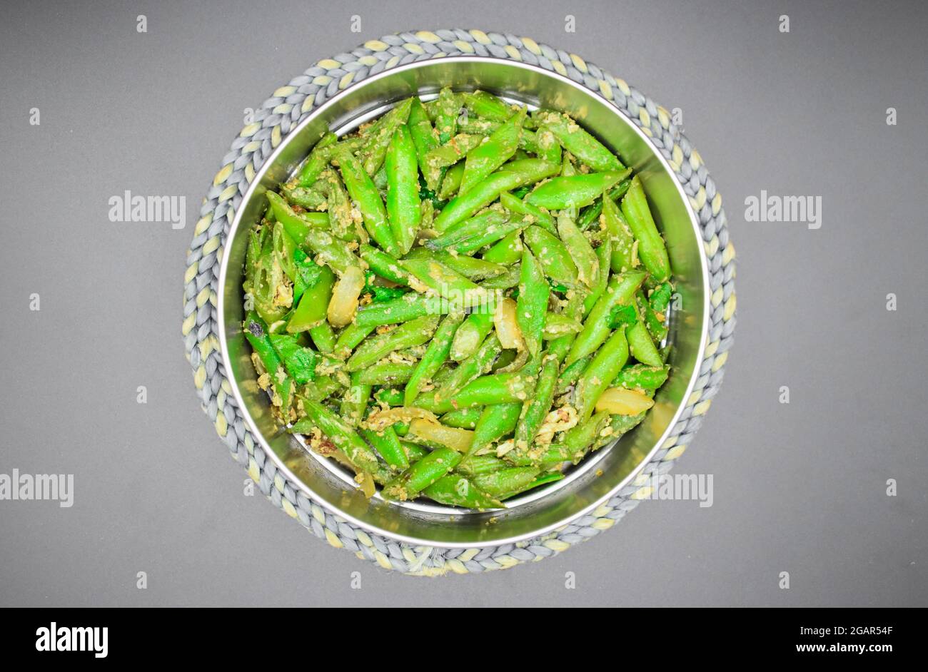 Ricetta di curry di fagiolo verde asiatico, birmano o Myanmar su piastra termoresistente. Vista dall'alto. Isolato su nero. Foto Stock
