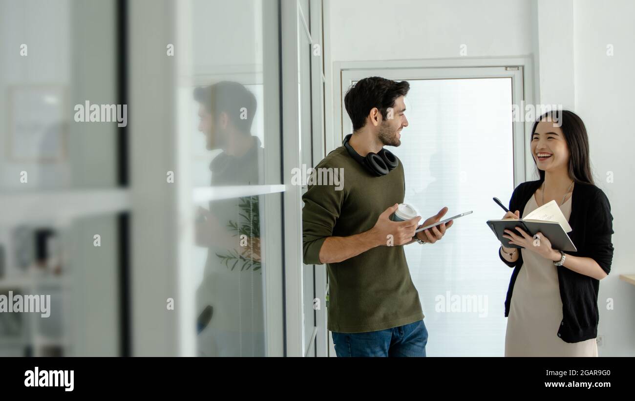 Due persone di affari in piedi e parlare e discutere all'esterno, planare e imparare con il partner felice o l'università Foto Stock