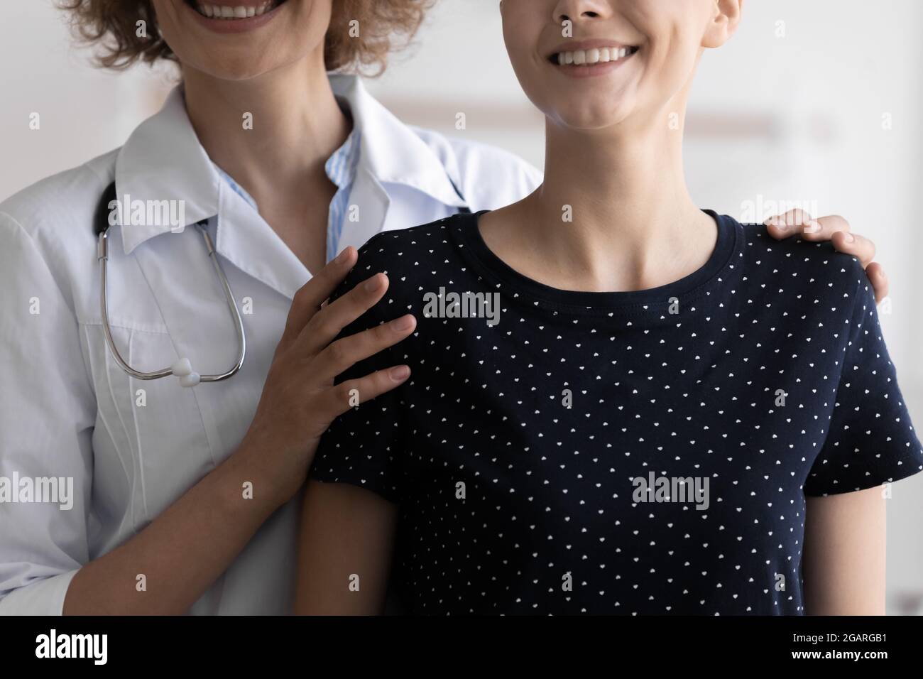 Sorridente gentile medico che sostiene la paziente femminile con cancro. Foto Stock