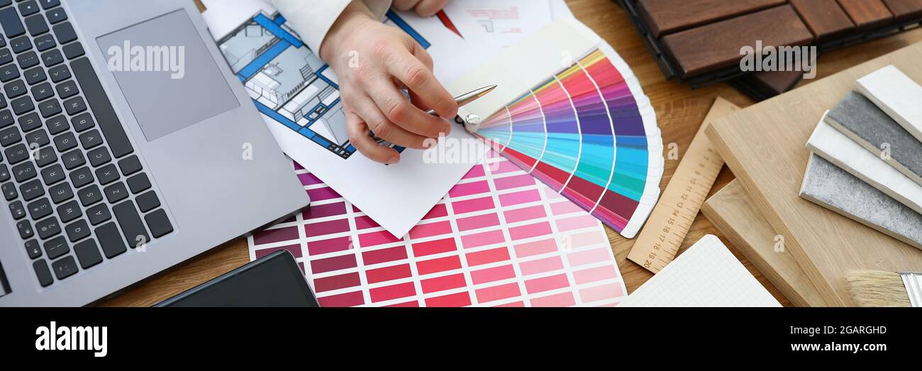 L'architetto designer maschile sceglie i colori dalla tavolozza dei colori sul posto di lavoro Foto Stock