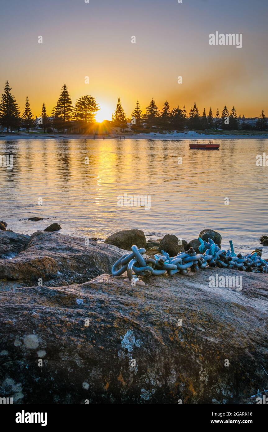 Un tramonto di un'ora blu dorata sulla baia di Middleton Beach ad Albany, Australia Occidentale con una catena di ancoraggio in primo piano in acciaio inossidabile. Foto Stock
