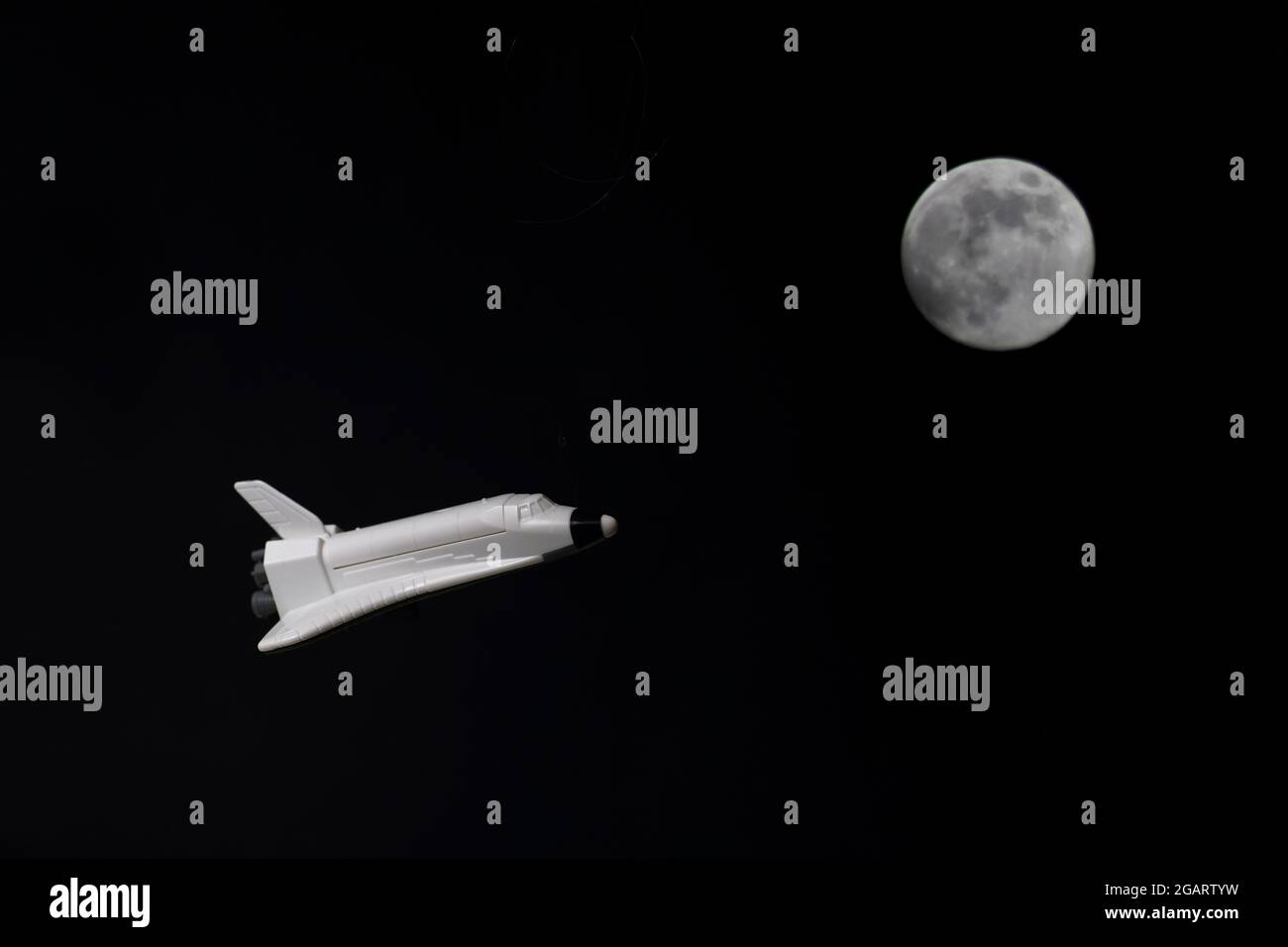 programma spaziale - astronave che vola sulla luna su sfondo nero Foto Stock