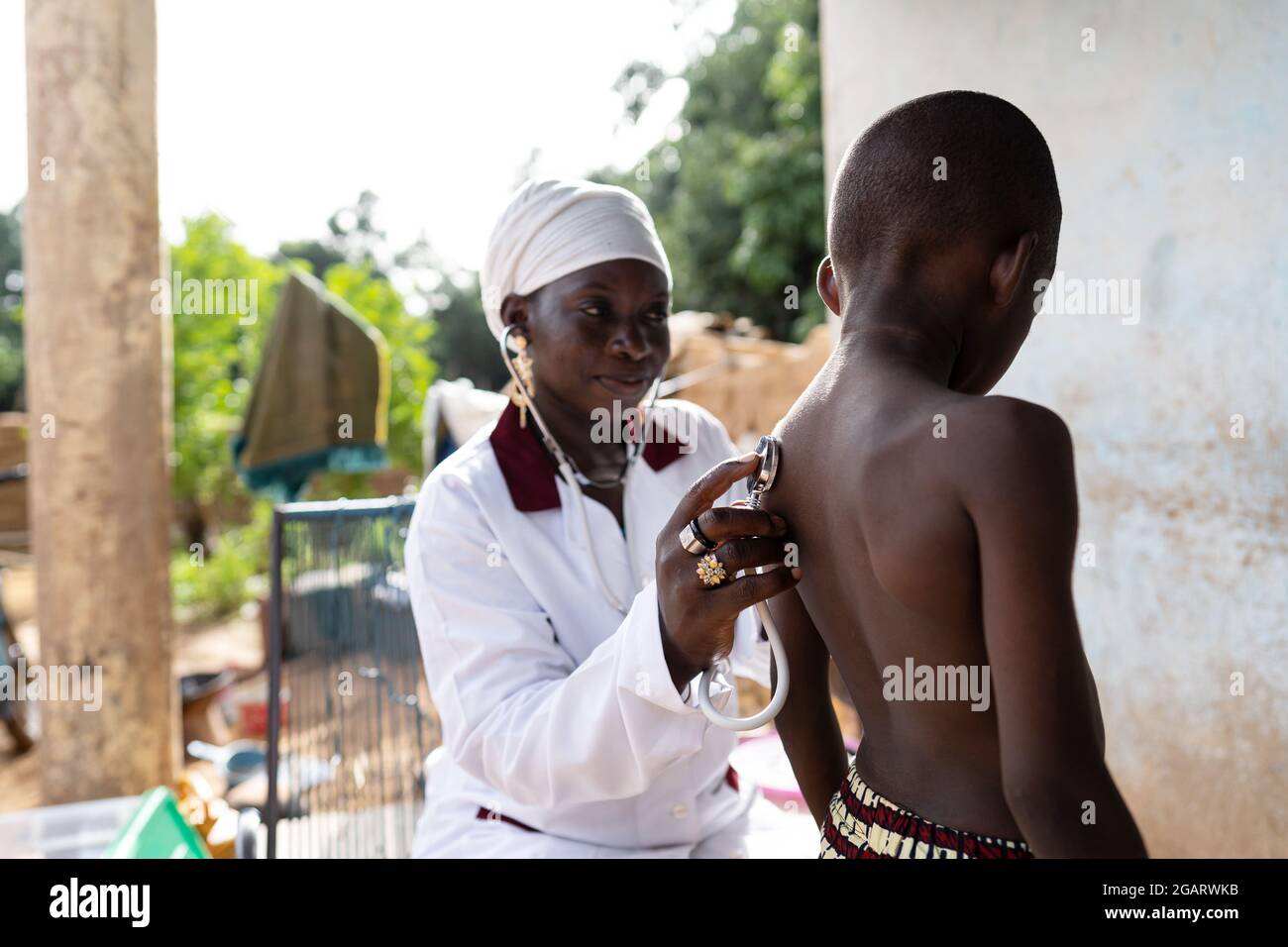 In questa immagine, un pediatra sta visitando una famiglia di villaggi africani per verificare lo stato di salute generale di un ragazzo nero malato con un sospetto infe Foto Stock