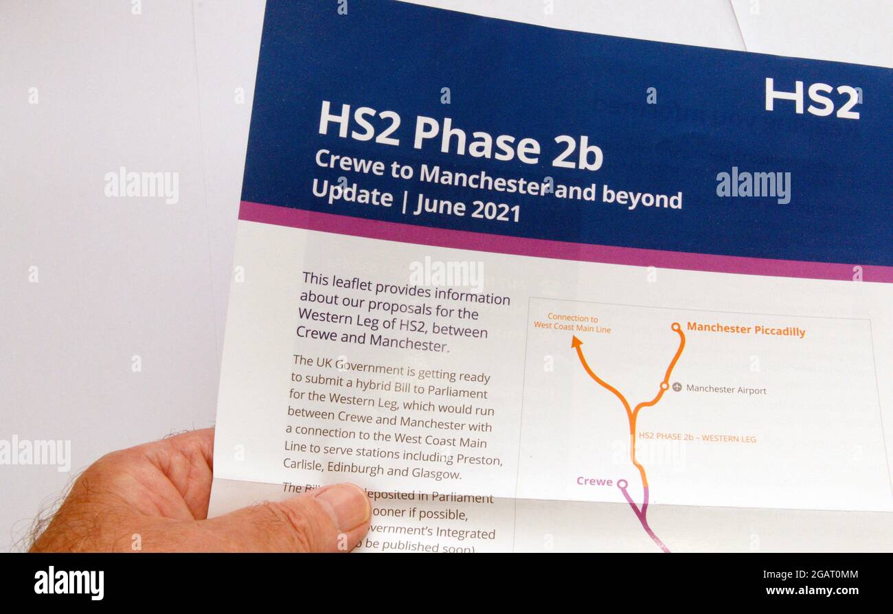 La mano dell'uomo anziano tiene un opuscolo che informa i residenti circa HS2 fase 2b, Crewe a Manchester e oltre la nuova linea di tirocinio pianificata. Foto Stock
