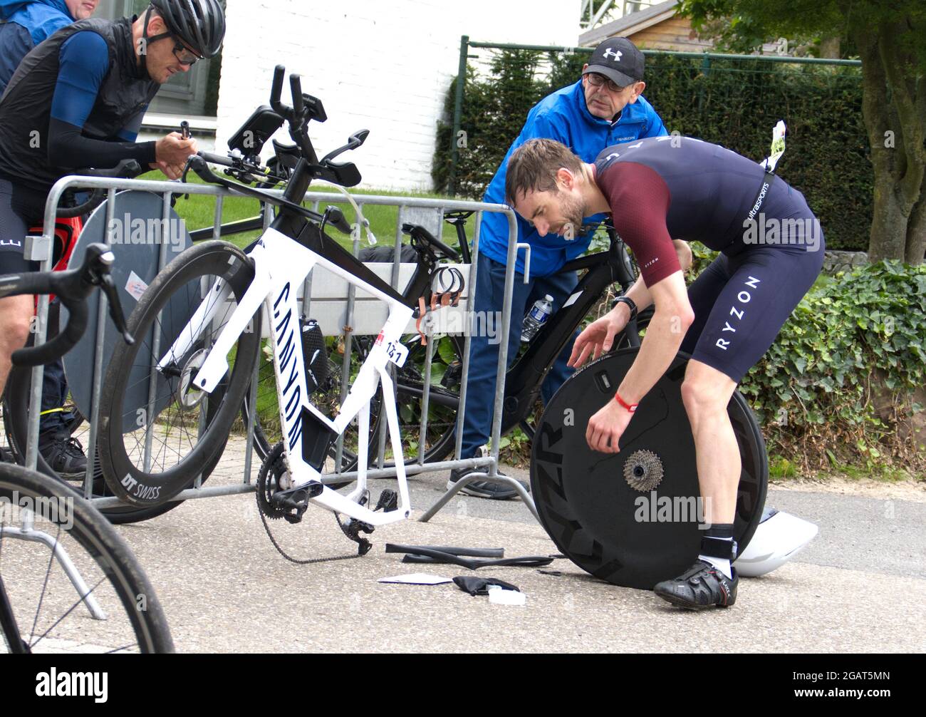 Maastricht, Paesi Bassi. 1 agosto 2021. Jan-Ole Gerschefski (bib no 1261) della Germania che fissa un pneumatico forato a lato del corso durante il triathlon Ironman 70.3 Maastricht-Limburg. A causa dell'acqua che scorre rapidamente nel fiume Mosa a seguito delle recenti inondazioni, la sezione di nuoto del corso è stata sostituita con una sezione di corsa supplementare, trasformando il triathlon in un evento Run-Bike-Run. Anna Carpendale/Alamy Live News Foto Stock