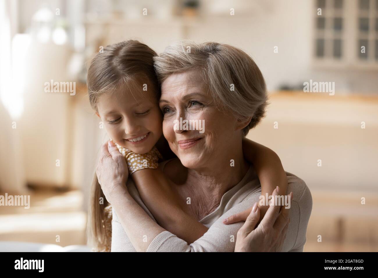 La testa ha sparato donna matura felice con hugging adorabile della bambina Foto Stock