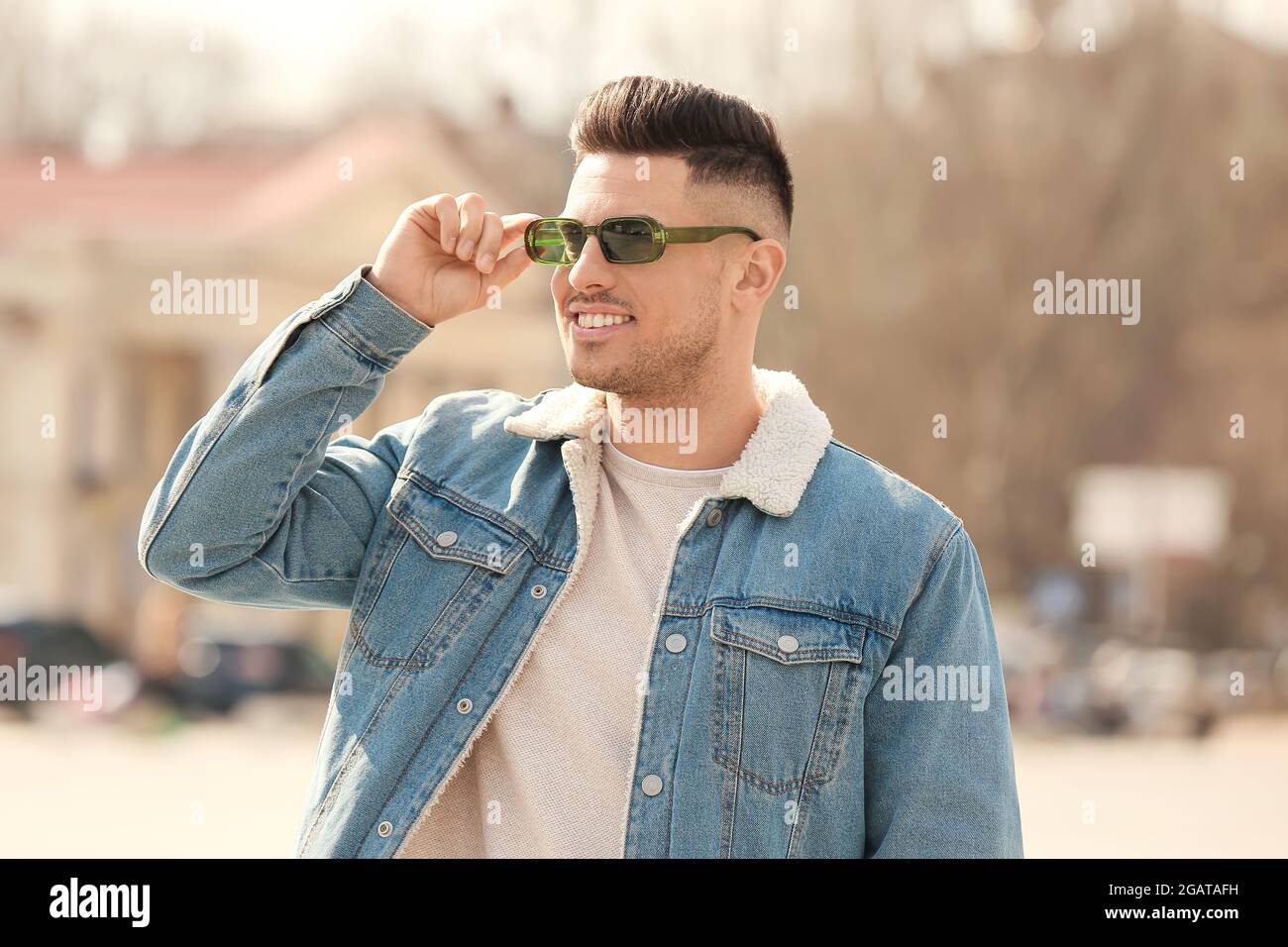Giovane uomo che indossa eleganti occhiali da sole all'aperto Foto stock -  Alamy