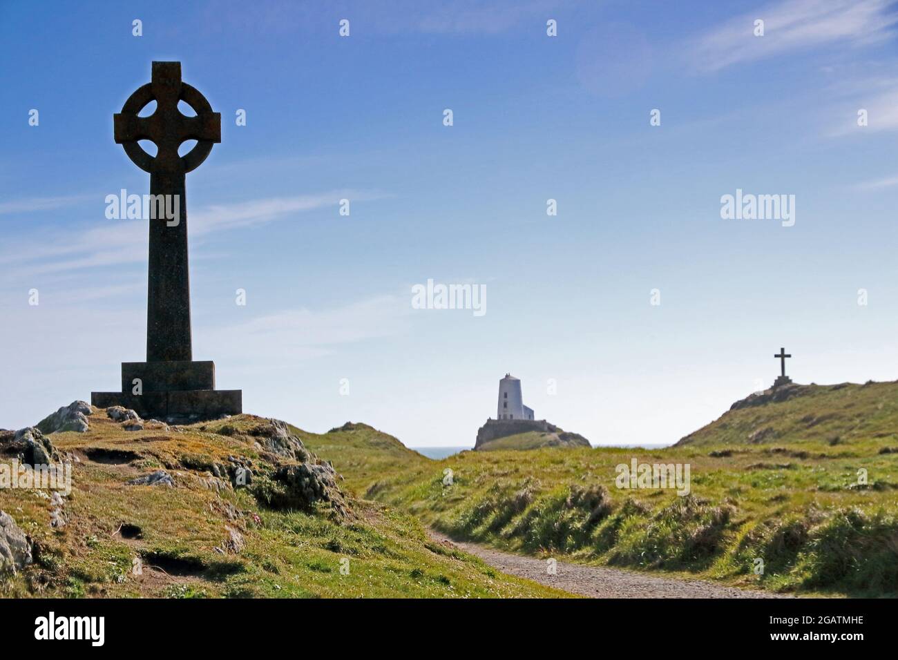 Croce di pietra, croce celtica e faro di Twr Mawr, isola di Llanddwyn, Anglesey Foto Stock