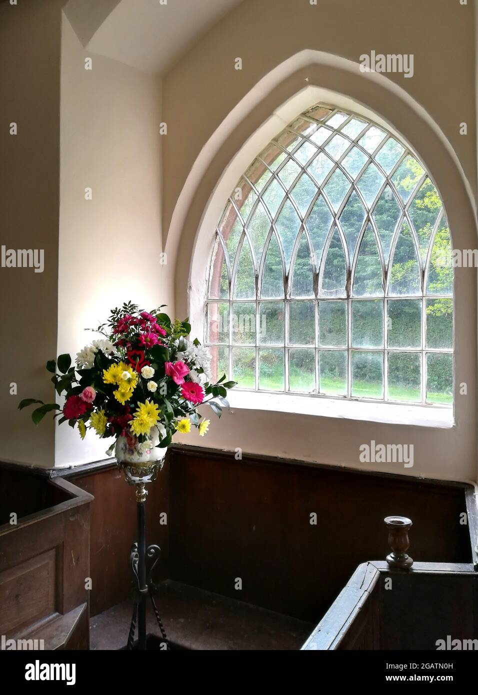 Una disposizione dei fiori in una finestra a St Mary's Village Church, Longnor, Shropshire, Inghilterra, Regno Unito Foto Stock