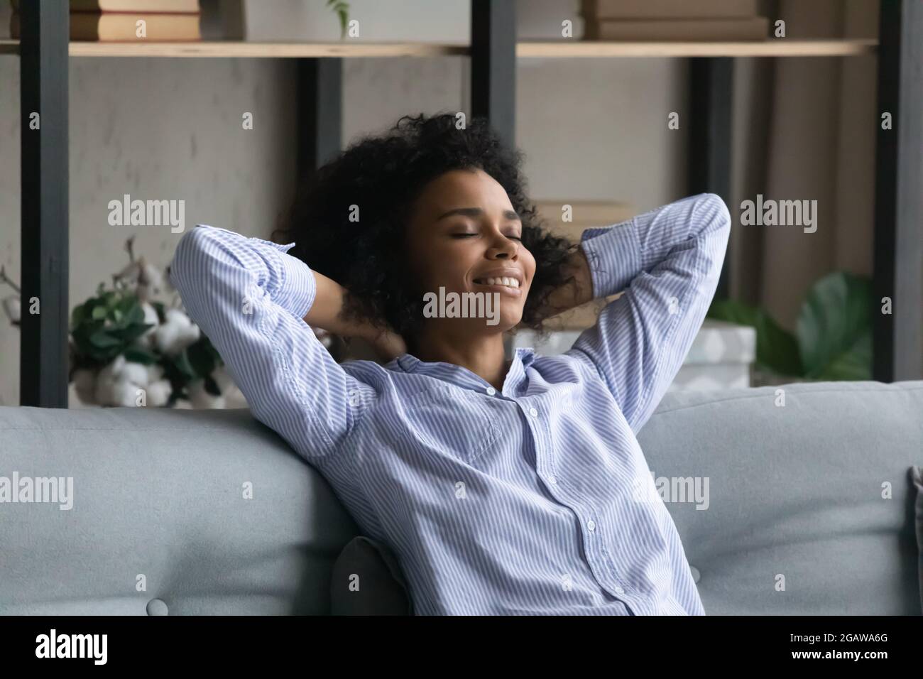 Calma biraciale donna rilassarsi sul divano letto Foto Stock