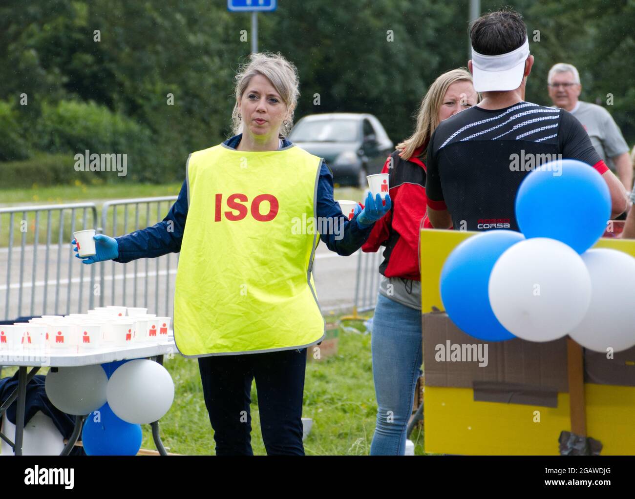 Maastricht, Paesi Bassi. 1 agosto 2021. I volontari consegnano bevande isotoniche e acqua ai triatleti che corrono durante la parte finale del triathlon Ironman 70.3 Maastricht-Limburg. A causa dell'acqua che scorre rapidamente nel fiume Mosa a seguito delle recenti inondazioni, la sezione di nuoto del corso è stata sostituita con una sezione di corsa supplementare, trasformando il triathlon in un evento Run-Bike-Run. Anna Carpendale/Alamy Live News Foto Stock