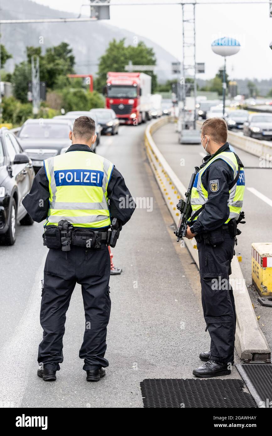 Kiefersfelden, Germania. 01 agosto 2021. Gli ufficiali di polizia federali tedeschi osservano il traffico sull'autostrada A93 al confine con l'Austria. La polizia federale ha iniziato a controllare i requisiti più rigorosi per i viaggiatori che tornano in Germania. Credit: Attias Balk/dpa/Alamy Live News Foto Stock