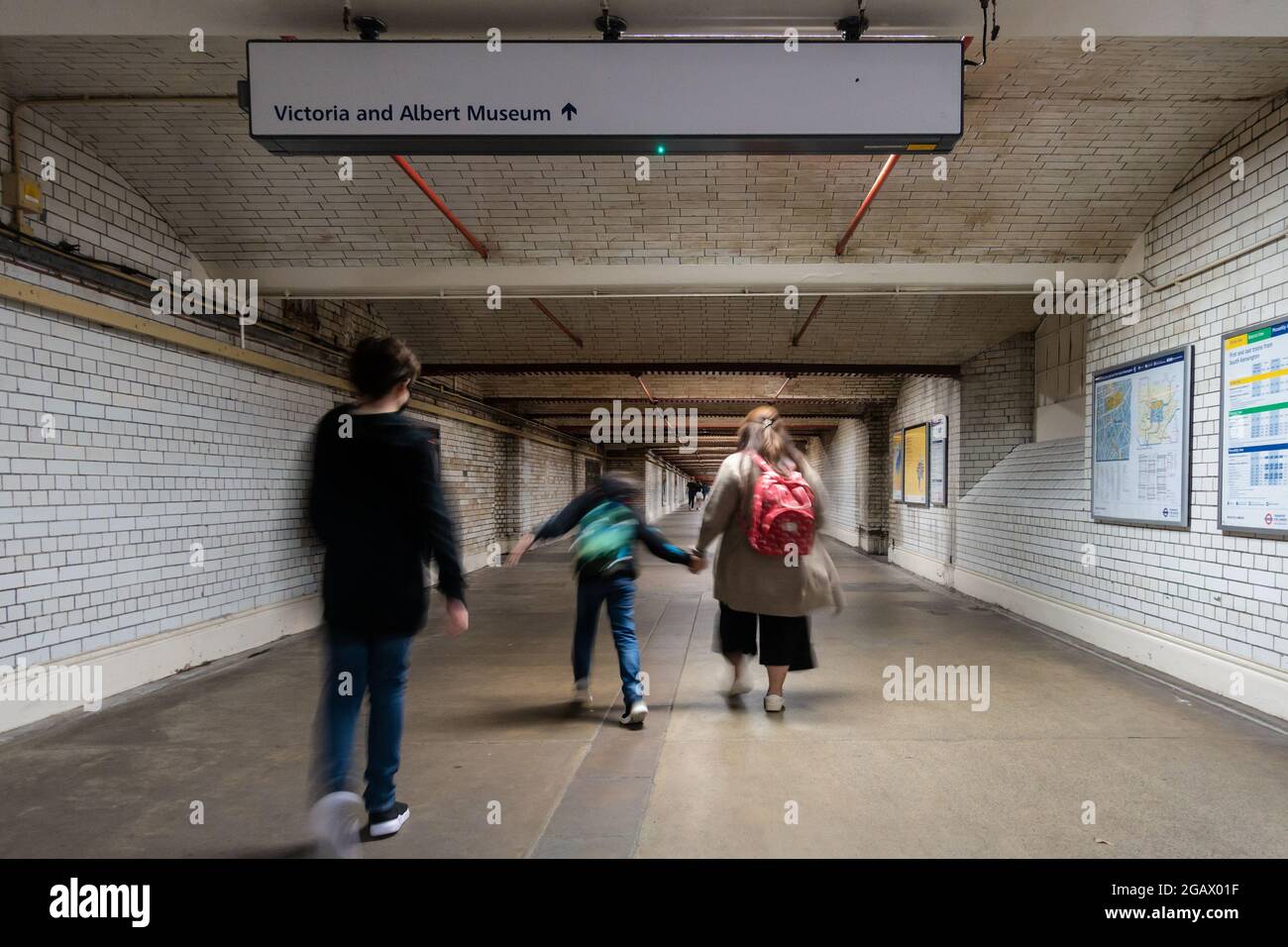 Una passeggiata in famiglia lungo il tunnel costruito in mattoni che collega la stazione di South Kensington con i musei gratuiti della zona. Foto Stock