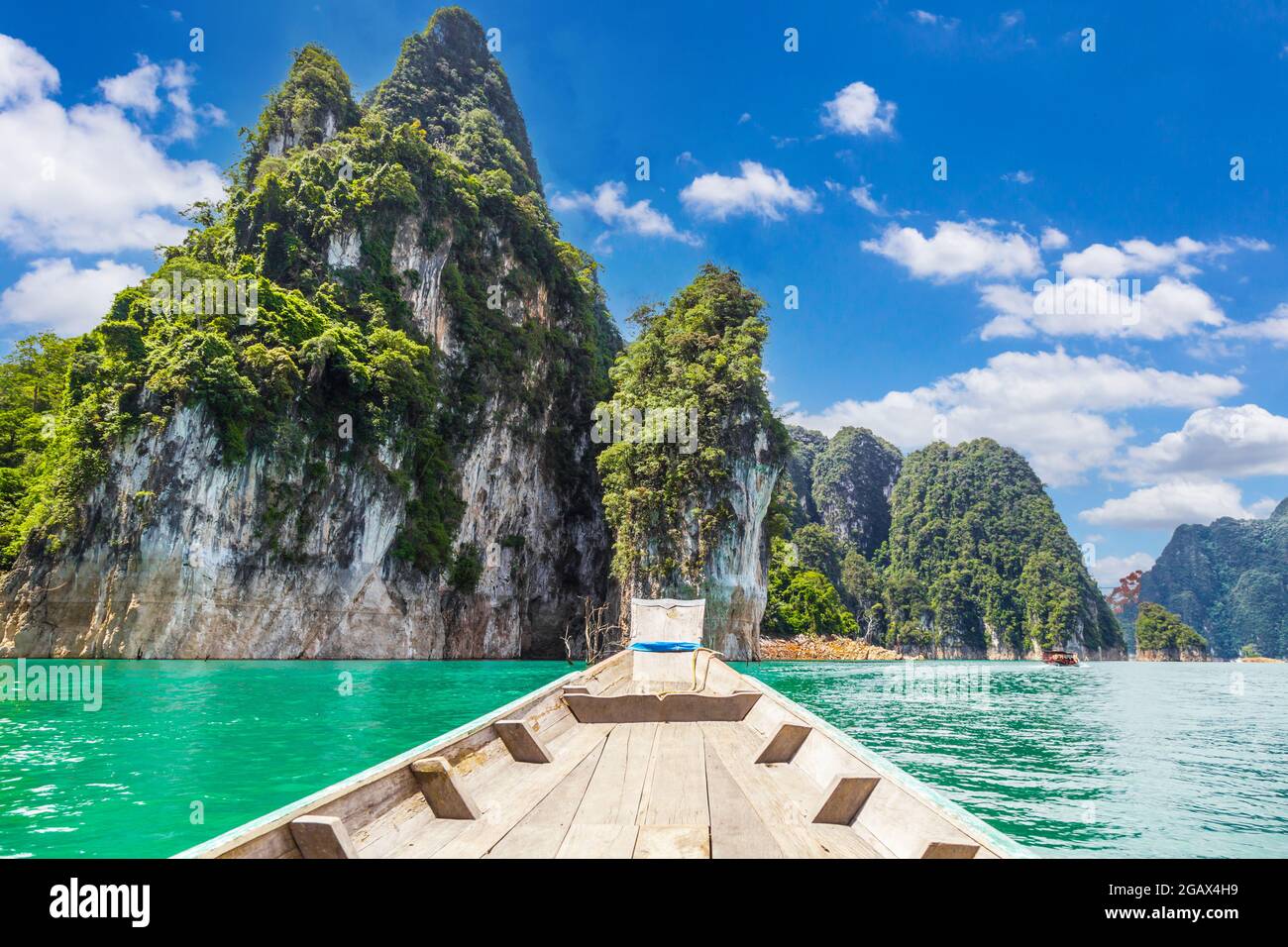 Tradizionale barca di legno tailandese a coda lunga su un lago con le montagne alla diga di Ratchaprapha o Khao Sok National Park, Surat Thani Provincia, Thailandia Foto Stock