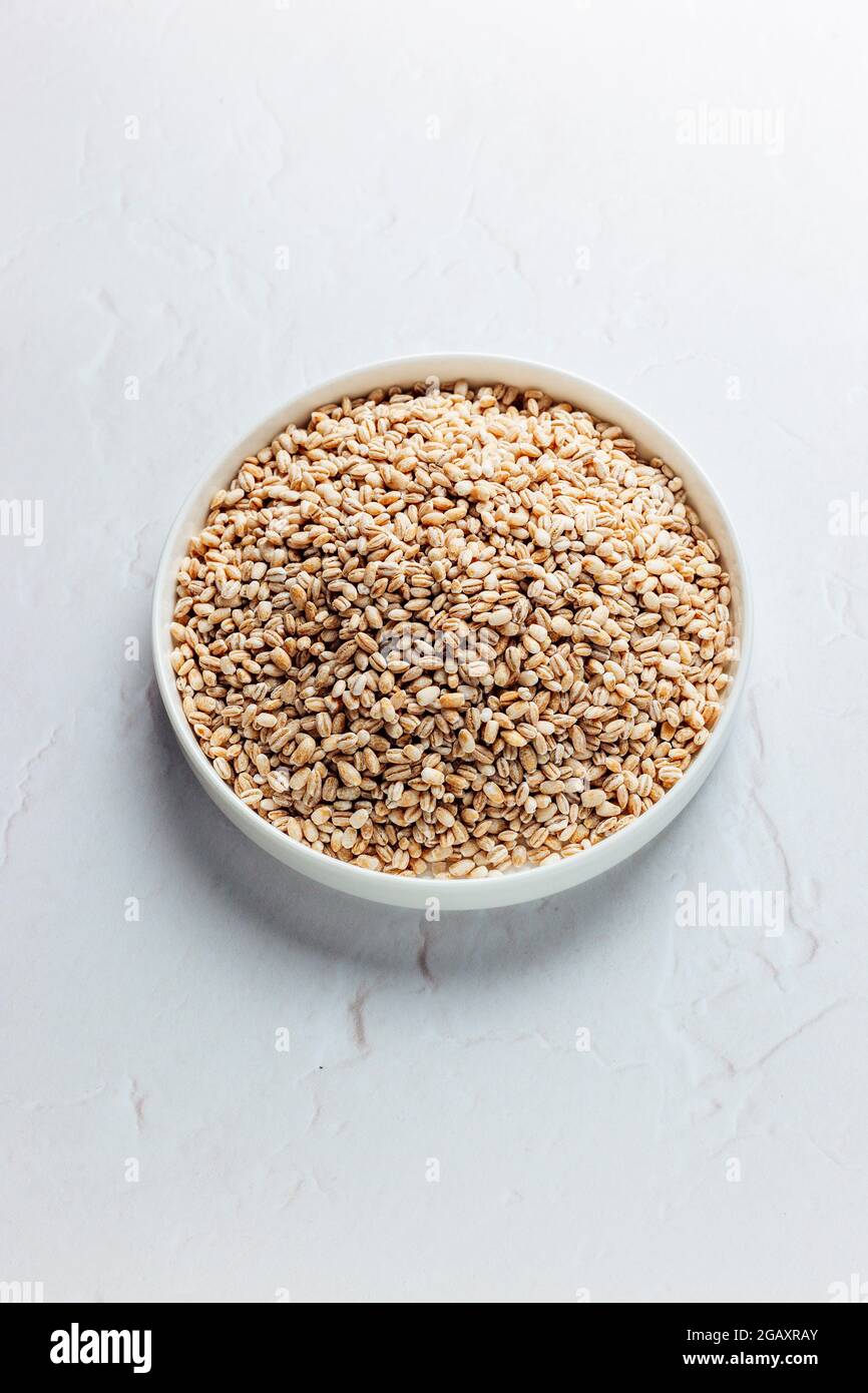 Pearl Barley in White Dish on a White background, Isolated – FOODPIX WHITE - COPYSPACE - SPAZIO PER IL TESTO Foto Stock