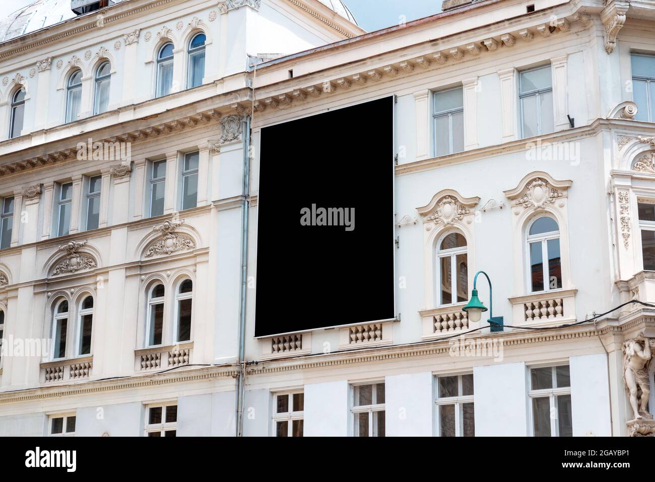 Superficie vuota del cartellone nero per il mockup sulla facciata dell'edificio della città vecchia Foto Stock