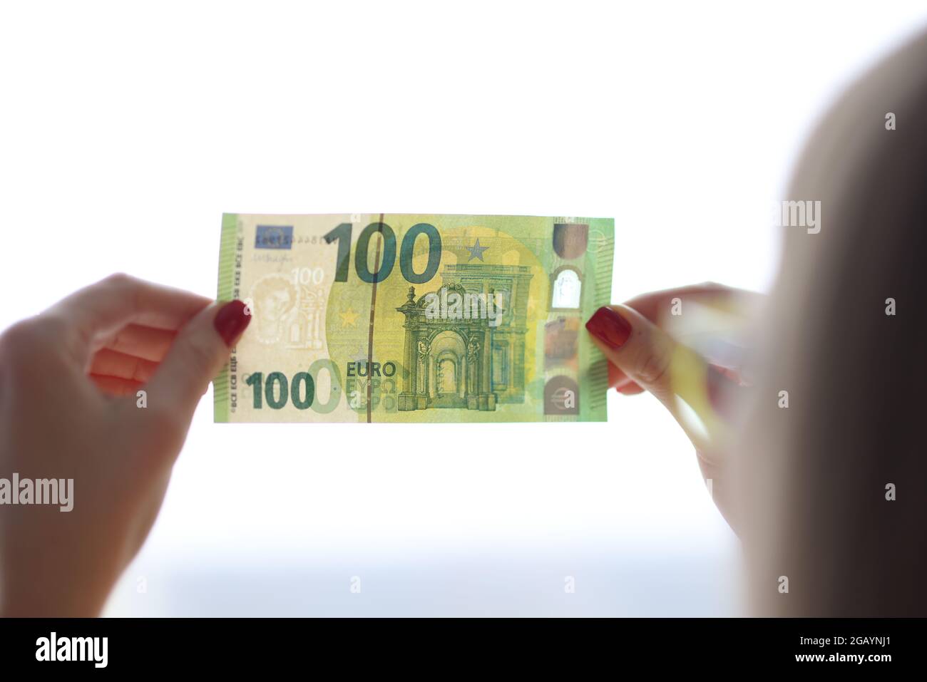 La donna controlla l'autenticità di un conto di centinaia di euro Foto Stock