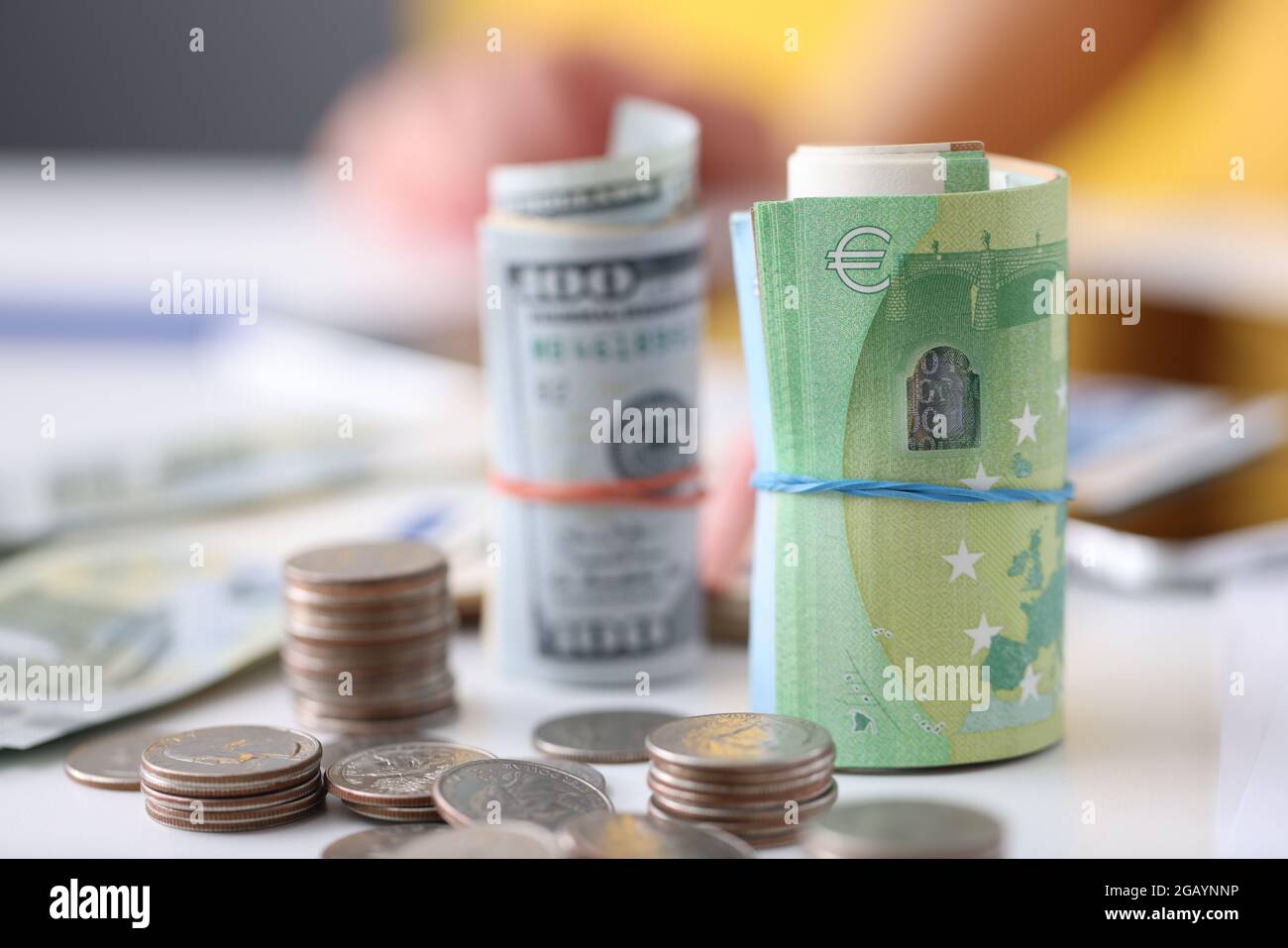 Cento dollari e cento banconote in euro con monete giacciono sul tavolo Foto Stock