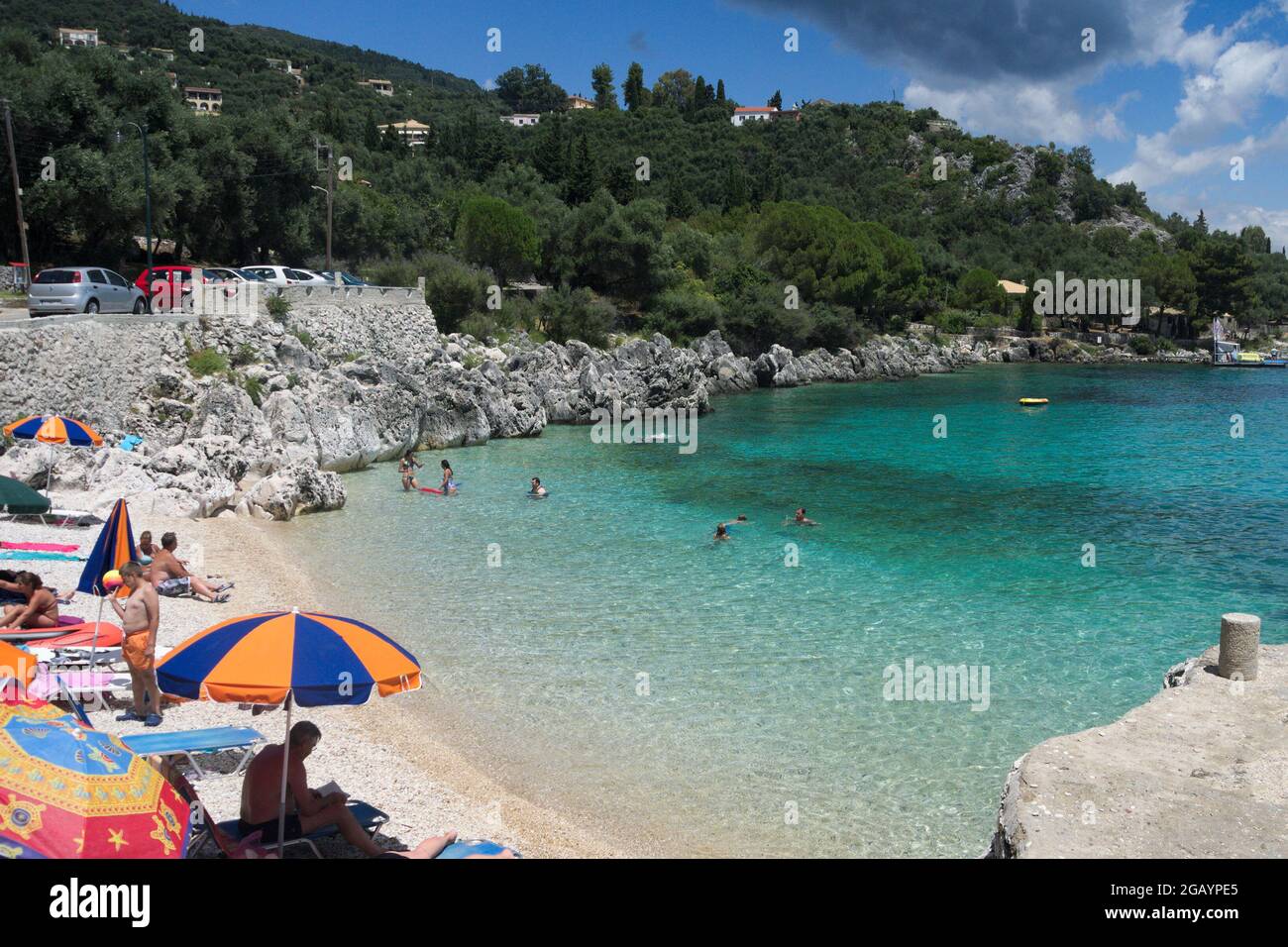 Nissaki, Corfù Grecia Luglio 10 2014 : spiaggia colorata, in una bella baia con villeggianti che si rilassano al sole estivo. Costa Nord-Est. Foto Stock