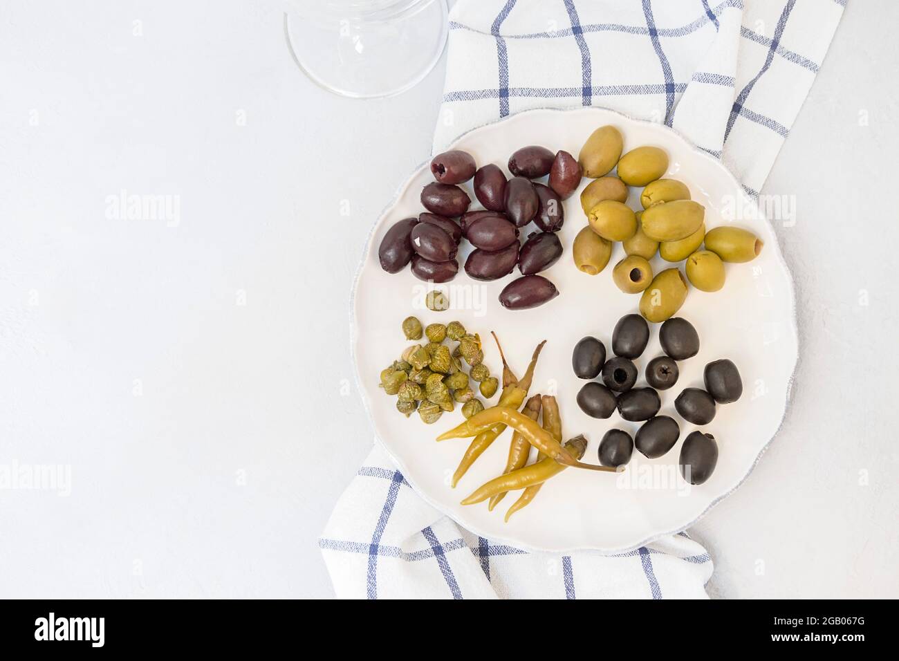 Antipasti italiani, diversi tipi di olive, capperi, peperoni, assortimento mediterraneo di cibi deliziosi, spuntini enologici Foto Stock