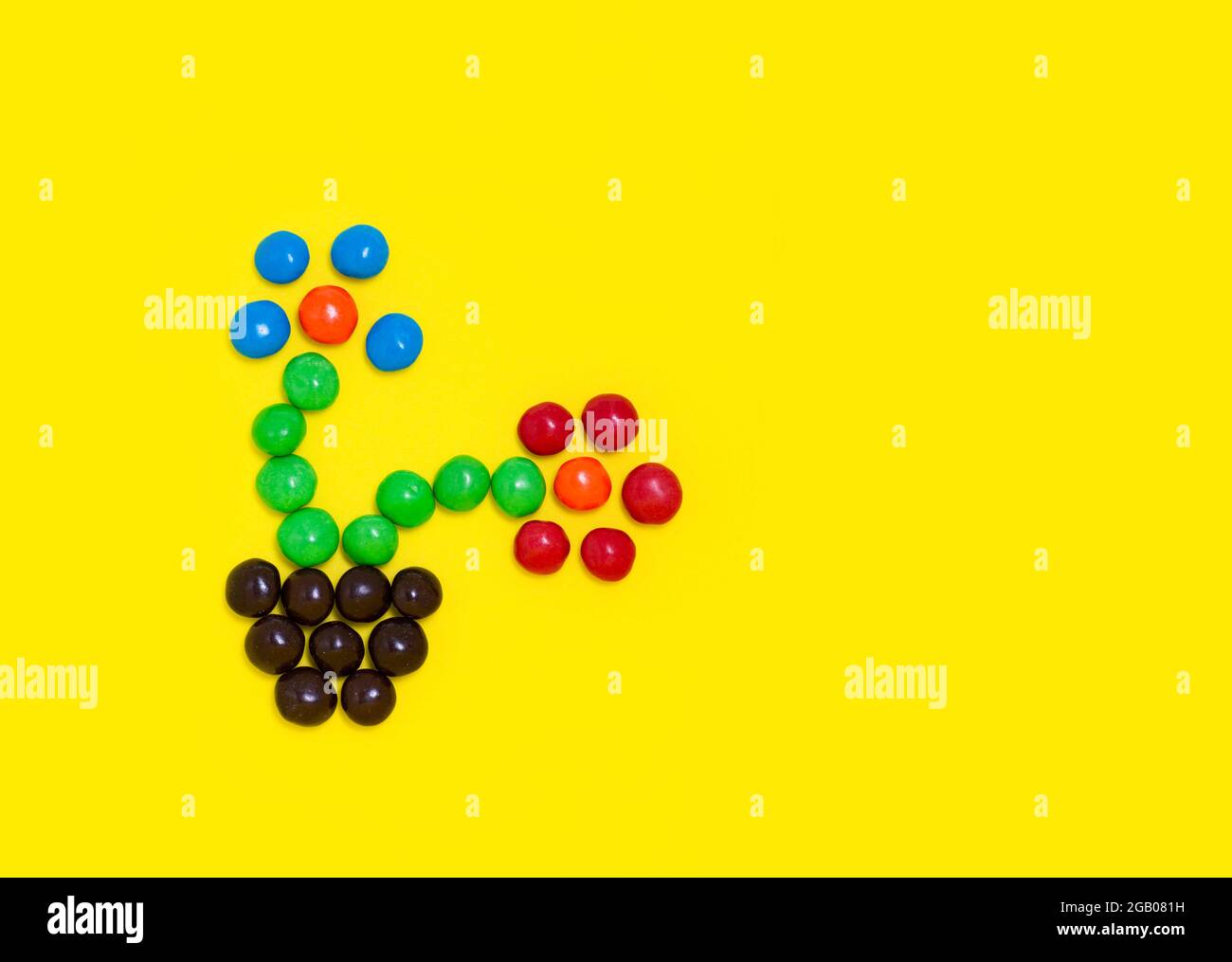 Fiori di caramelle da canditi colorate fioriture. Dolci colorati per le vacanze con luminoso spazio per la copia del testo. Concetto di primavera Foto Stock