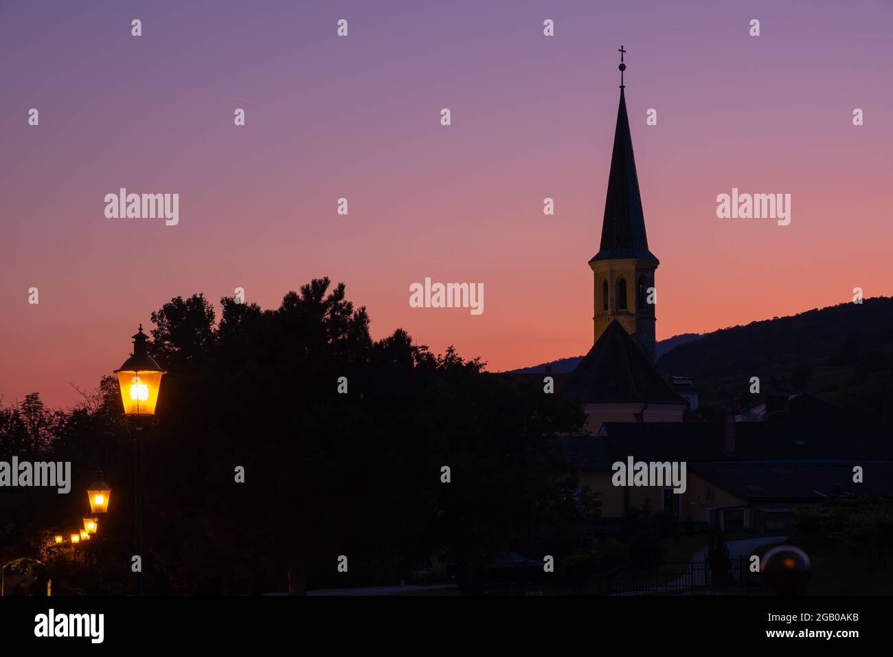 Silhouette vista della chiesa parrocchiale ortodossa in serata a Gumpoldskirchen, un luogo famoso per il suo vino e Heurigers come una grande collina vigneti. Foto Stock