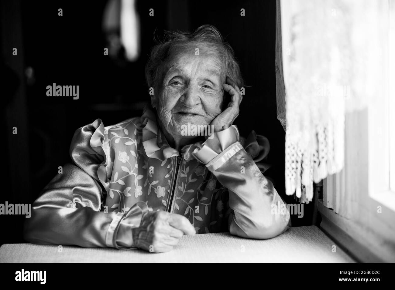 Ritratto di una vecchia donna in casa sua, primo piano. Foto in bianco e nero. Foto Stock