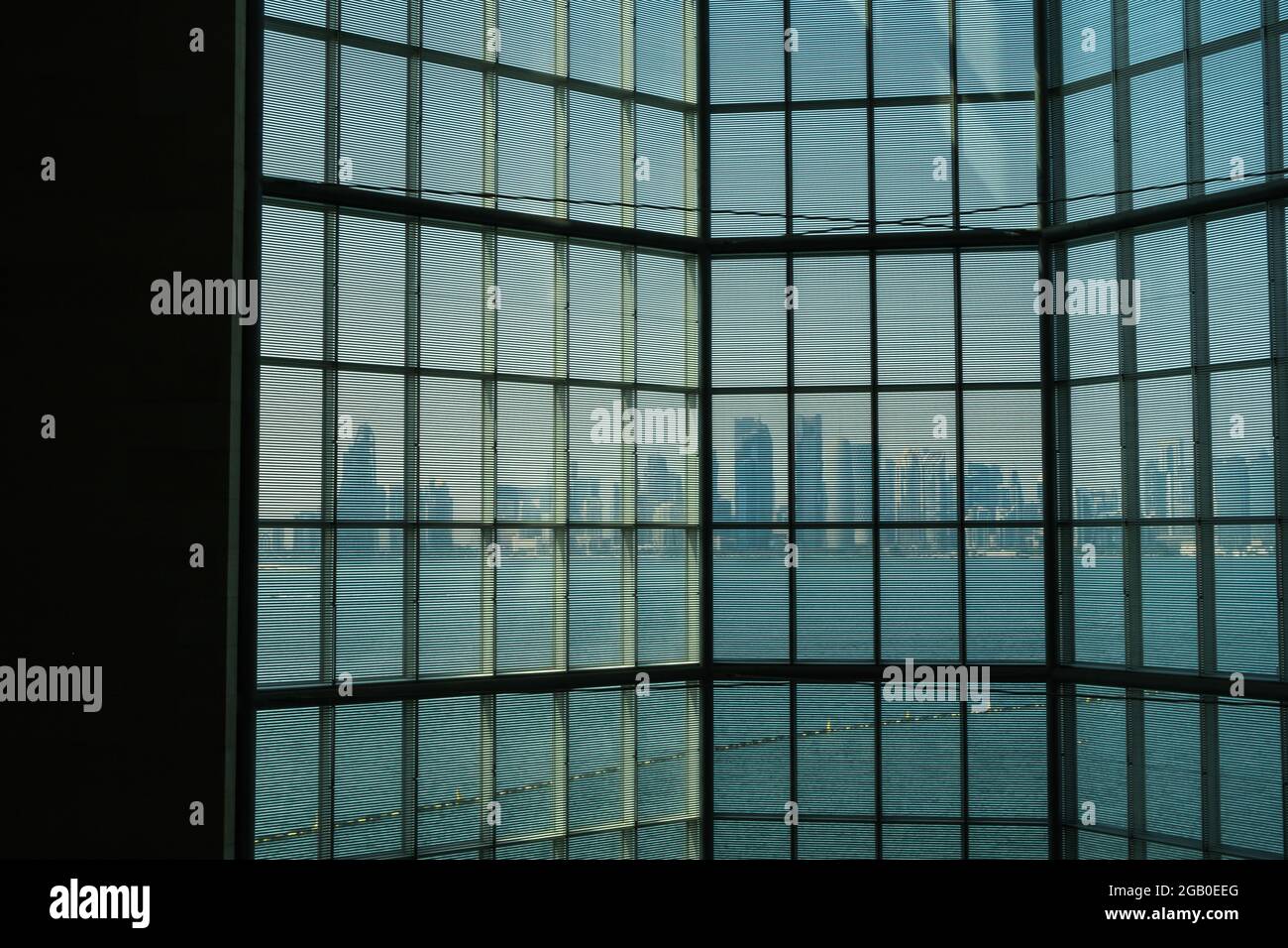 Doha, Qatar - 13 ottobre 2019: La vista delle ombre del paesaggio urbano attraverso la finestra di vetro del Museo d’Arte Islamica, uno dei collec più completi del mondo Foto Stock