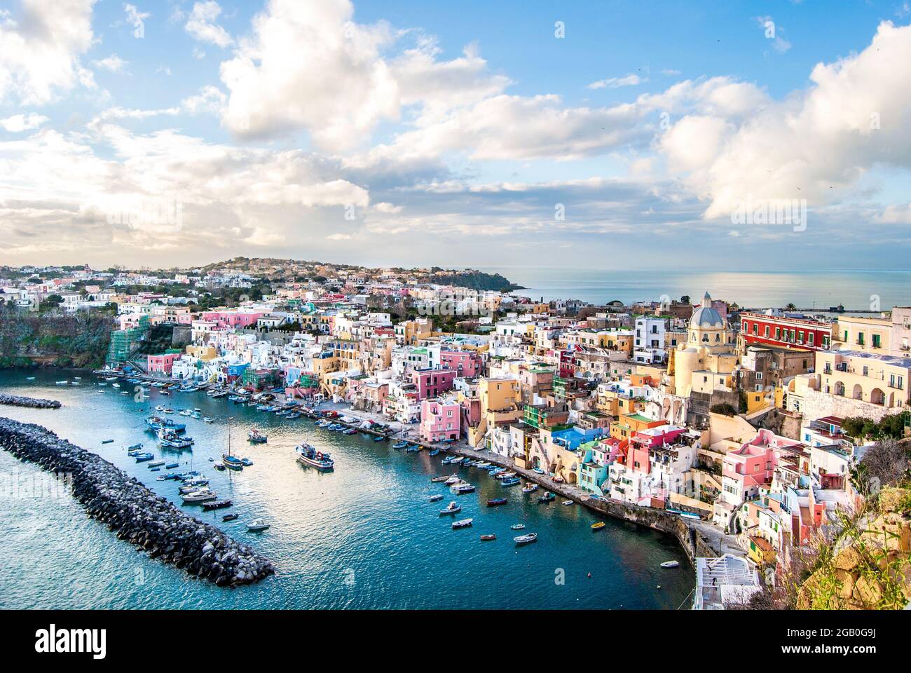 Vista panoramica di Marina Corricella, un villaggio di pescatori sull'isola di Procida, con edifici colorati, porto e barche, nell'isola di Procida, Napoli Foto Stock