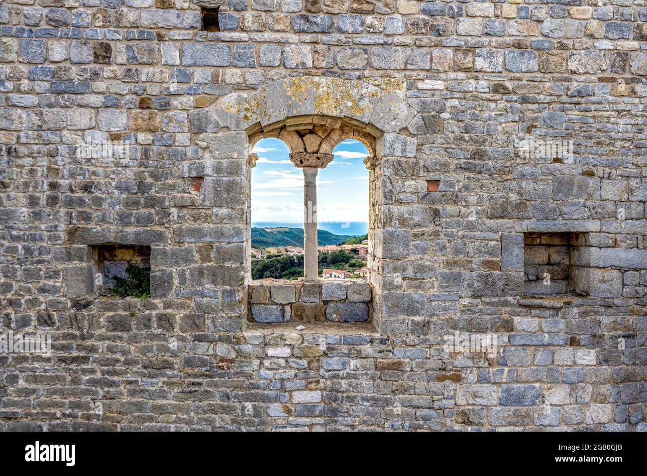 Una finestra tra i resti della Rocca medievale, costruita nel XII secolo, sulla collina sopra Campiglia Marittima, provincia di Livorno Foto Stock