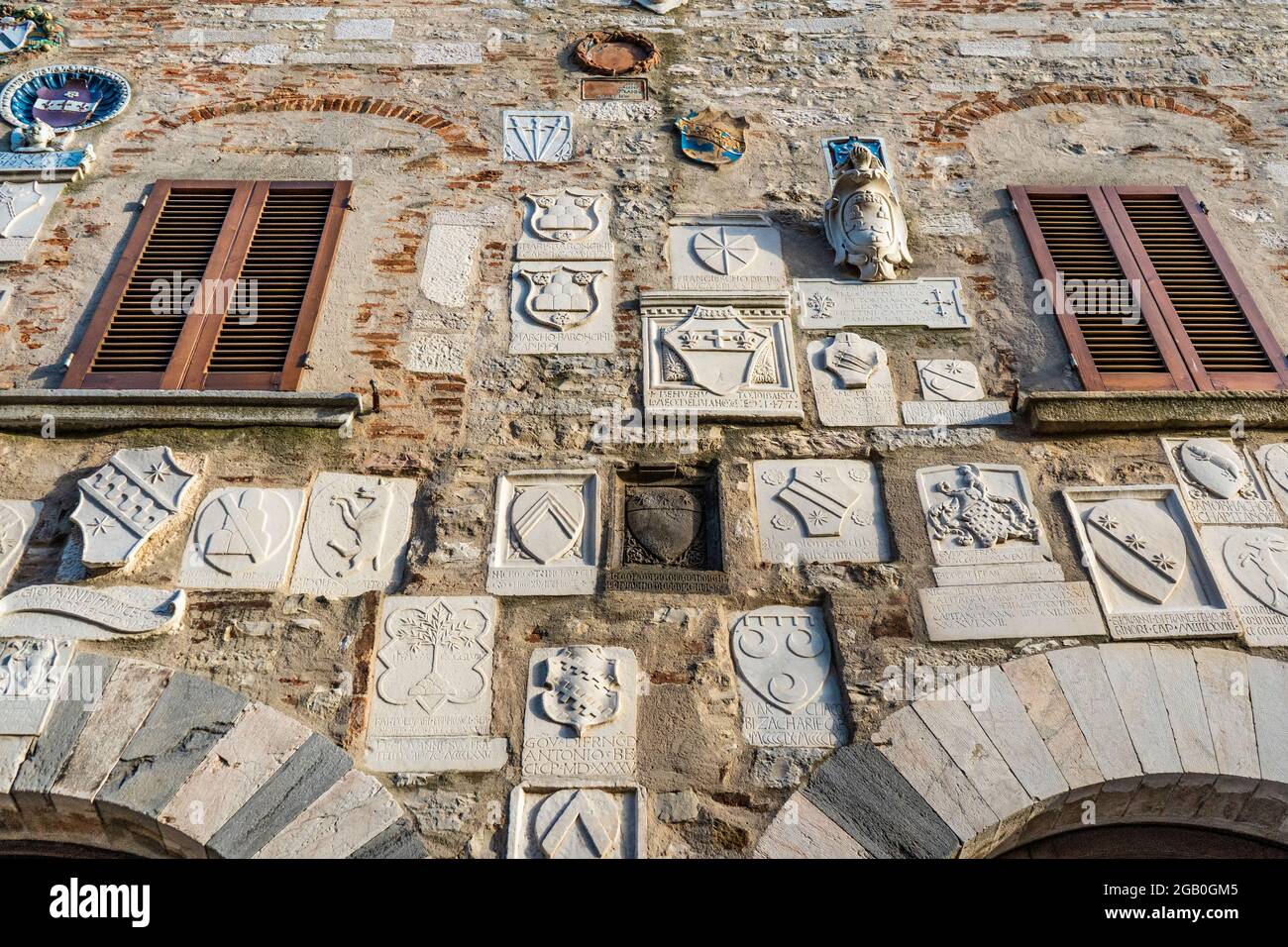 La facciata di Palazzo Pretorio, antica sede del potere politico e militare, con stemmi e iscrizioni, a Campiglia Marittima Foto Stock