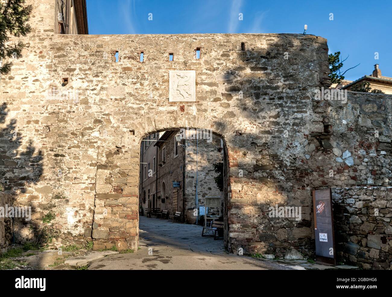 L'ingresso del borgo medievale di Populonia con lo stemma della famiglia Appiani, comune di Piombino, Toscana, Italia. Foto Stock
