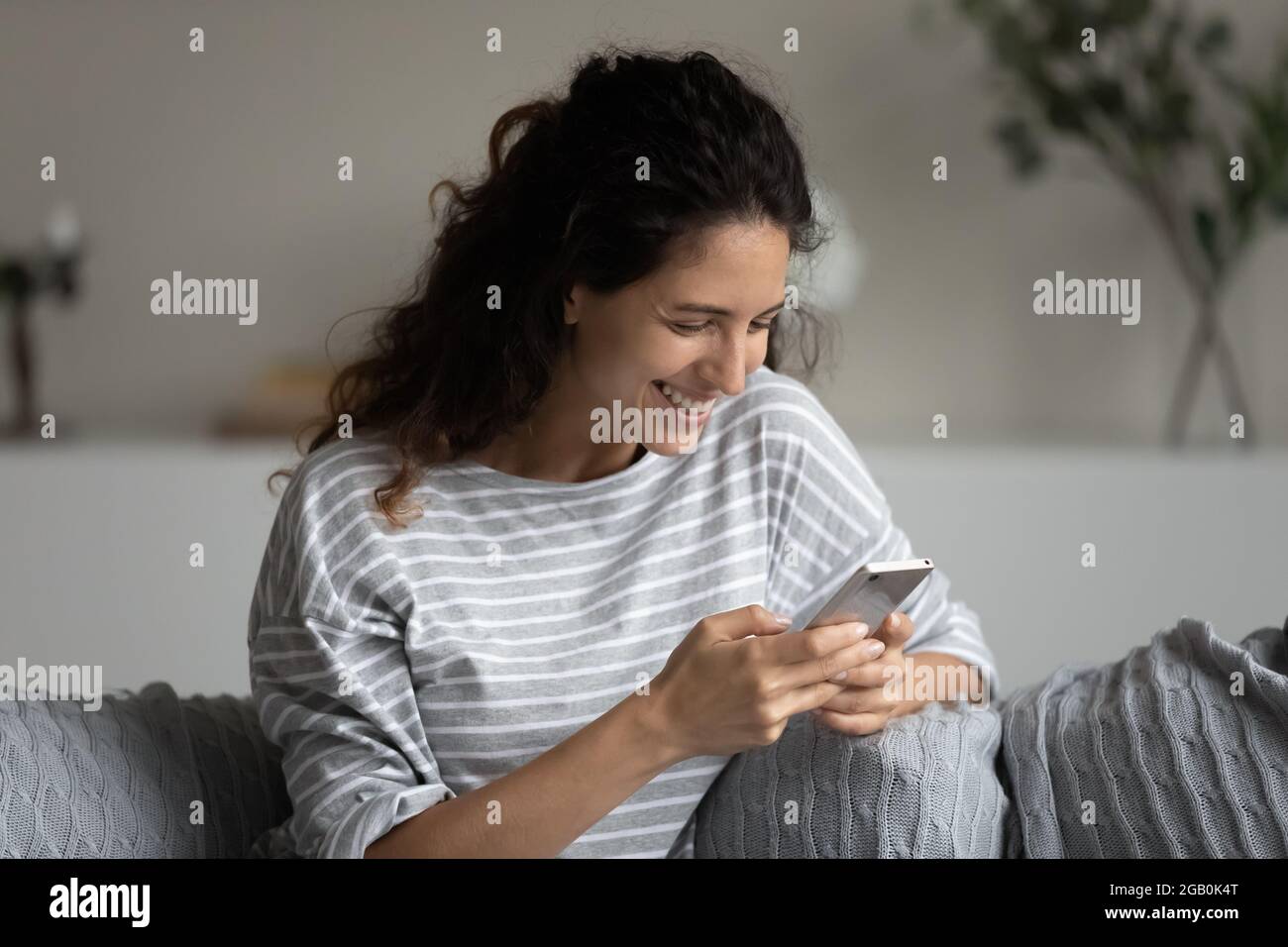 Buon utente di telefonia mobile entusiasta di buone notizie, utilizzando smartphone Foto Stock