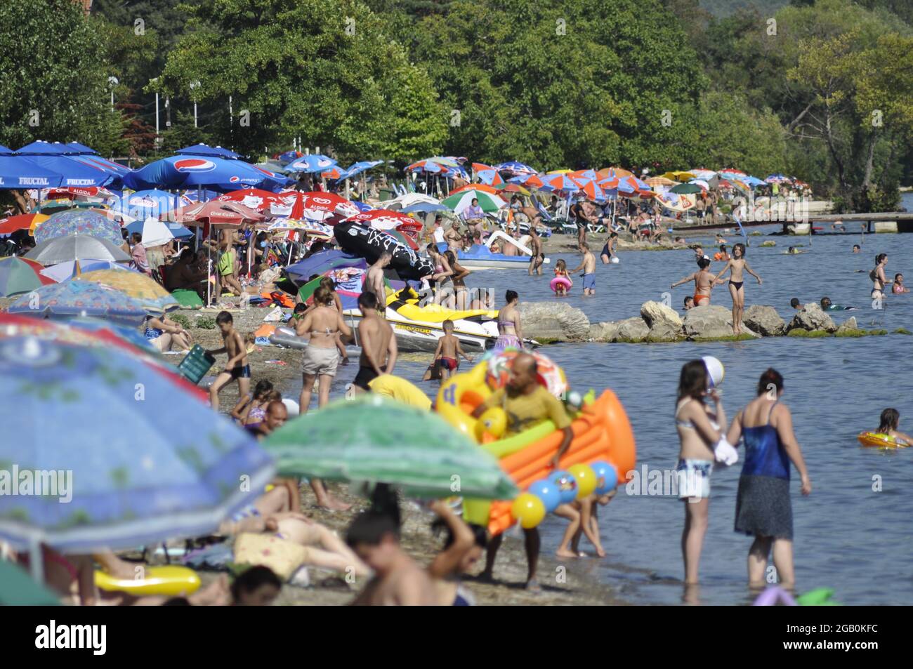 Le persone godono dell'acqua e delle onde sulla spiaggia. Sport estivi. Foto Stock