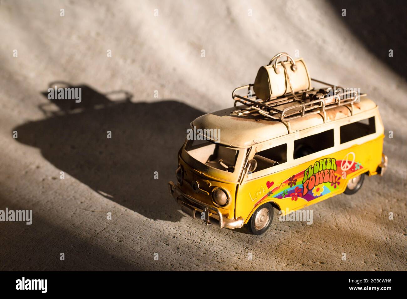 Piccolo giocattolo giallo furgone hippie. Concetto di vacanza, viaggio Foto Stock