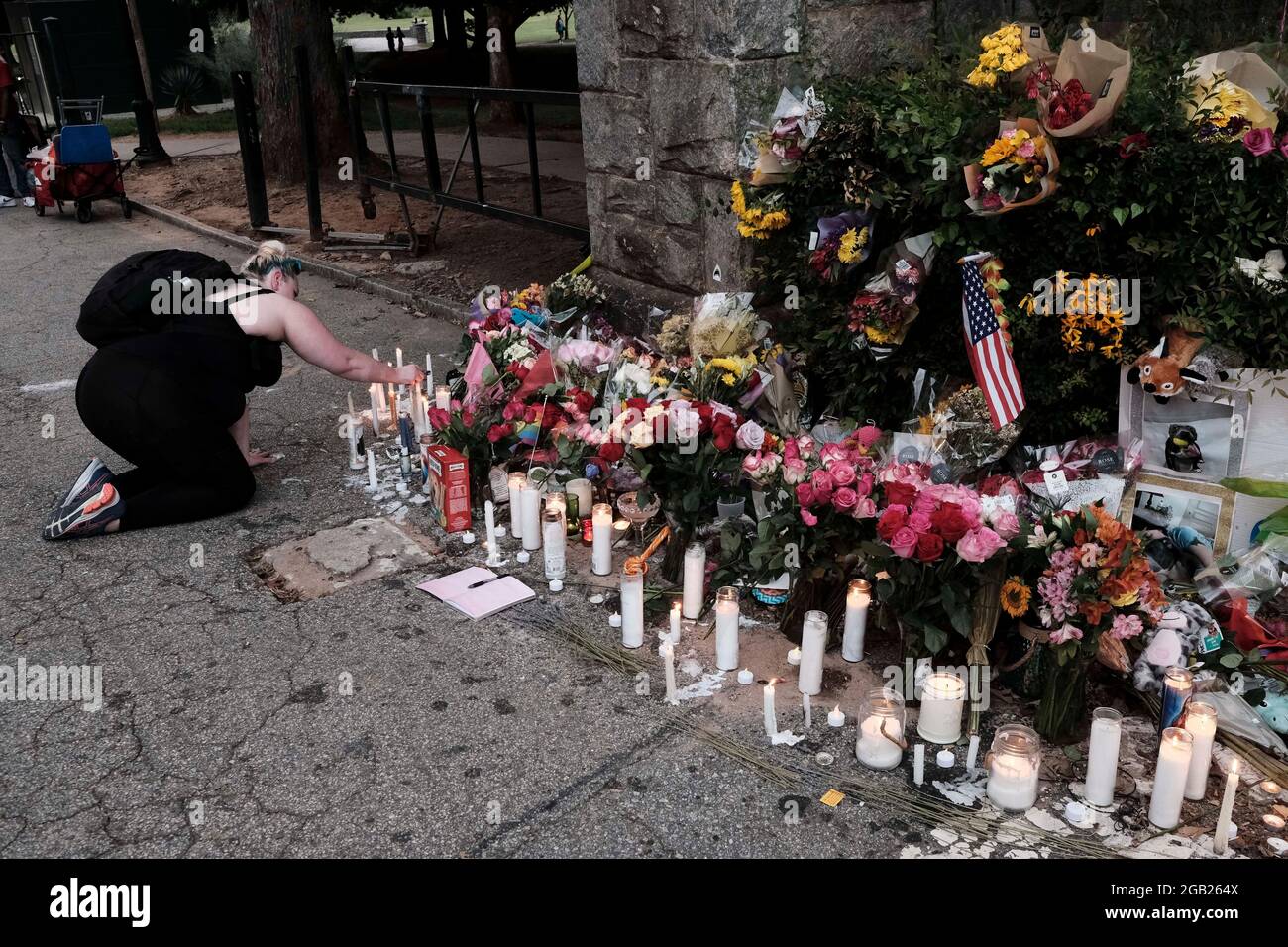 Atlanta, Georgia, Stati Uniti. 1 agosto 2021. Un membro del Midtown di Atlanta mette una candela in un memoriale di fortuna al Piedmont Park per LGBTQ Atlantan Katherine Janness e il suo cane, Bowie; entrambi sono stati trovati morti al Piedmont Park all'inizio di mercoledì intorno alle 1:00. Janness è stato trovato con ferite di stab multiple. E' in corso un'indagine, in quanto non sono stati individuati sospetti e non sono stati effettuati arresti in questo momento. (Immagine di credito: © John Arthur Brown/ZUMA Press Wire) Foto Stock