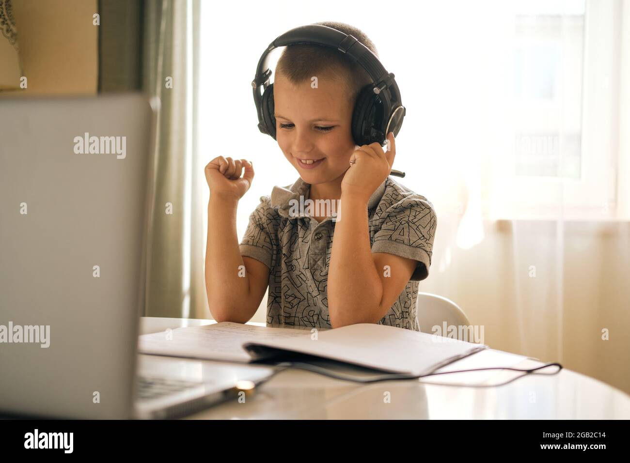 Scolaresche in cuffia utilizzando un computer portatile mentre si lavora a casa o durante la lezione online. Concetto di formazione online. Foto Stock