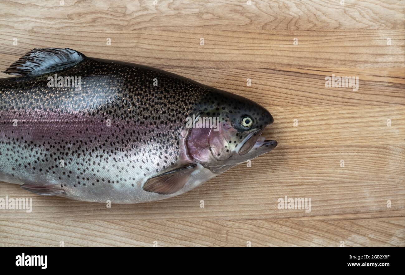 Pesce crudo su sfondo di legno. Trota. Vista dall'alto. Spazio libero per il testo Foto Stock