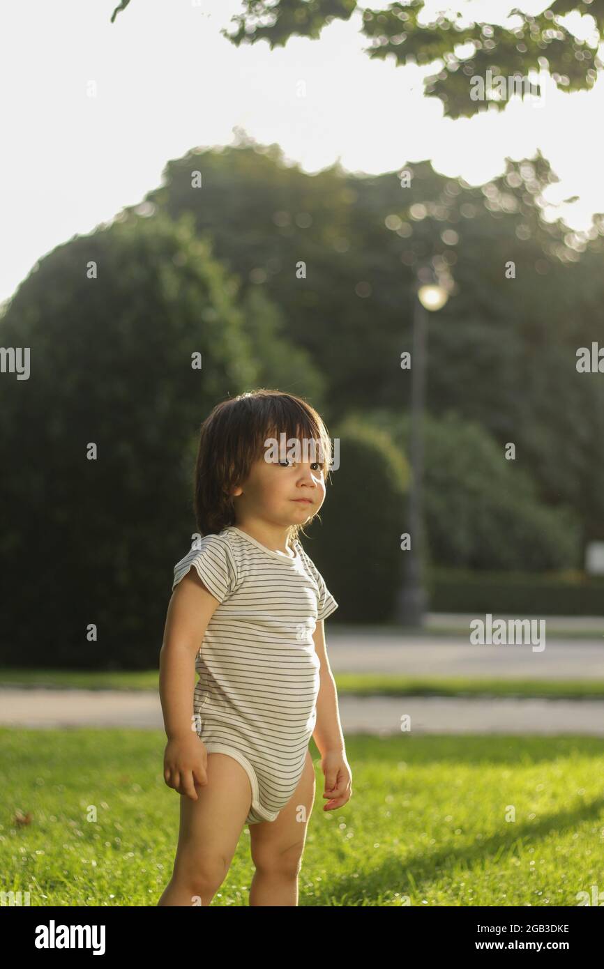 piccolo ragazzo latino di 1 anno nel parco al tramonto Foto Stock