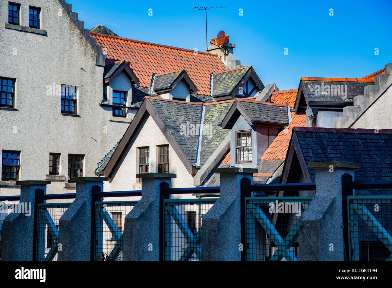 Vista su case con tetti spioventi da terrazzino con ringhiera ornata Foto Stock