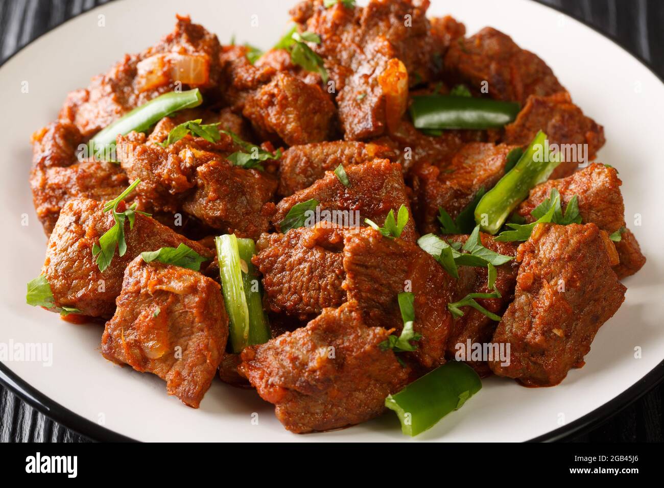 Il Tibs è un piatto etiope composto da carne fritta in padella e verdure cotte nel piatto sul tavolo. Orizzontale Foto Stock