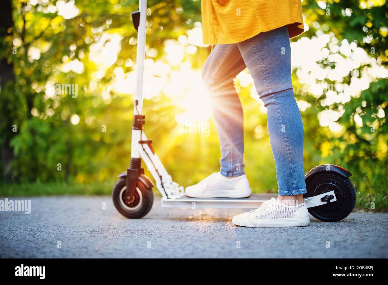 Donna in sella a uno scooter nel parco in estate Foto Stock